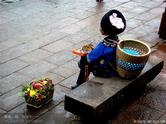 我拍下古城路边卖花的苗族阿妈.